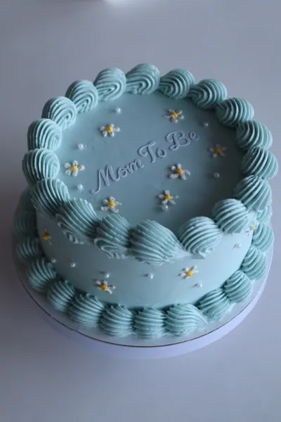 Blå hjertekage med dekorativ frosting og skrift