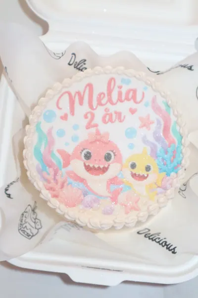 Lille hvid børnekage med farverige figurer og pasteldekoration
