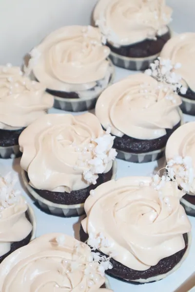 Cupcakes med lys frosting sprøjtet som roser